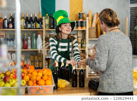 Female vendor in St. Patrick hat offers to buy male vendor traditional Irish ale Female vendor in St. Patrick hat offers to buy male vendor traditional Irish ale 120629441