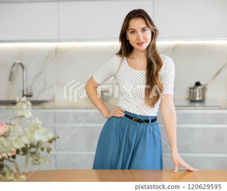 Portrait of satisfied woman in modern kitchen at home 120629595