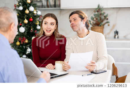 Couple discussing deal with salesman in kitchen 120629613