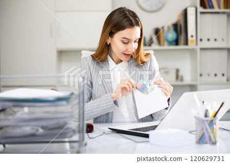 Woman office worker with wage packet 120629731