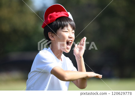 A boy playing with a red and white hat on his head A boy playing with a red and white hat on his head 120629778