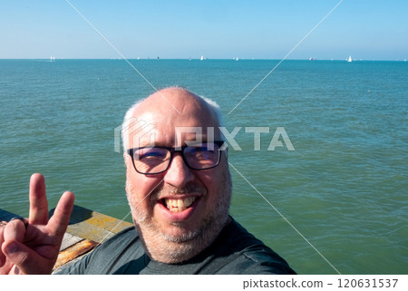 Joyful and extremely Happy Selfie taken by the Beautiful Sea showcasing a Relaxed Peace Sign Gesture Joyful and extremely Happy Selfie taken by the Beautiful Sea showcasing a Relaxed Peace Sign Gesture 120631537