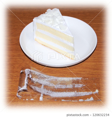 The film is peeled off the shortcake, folded, and placed on a wooden table, with white cream still stuck to the inside. The film is peeled off the shortcake, folded, and placed on a wooden table, with white cream still stuck to the inside. 120632234