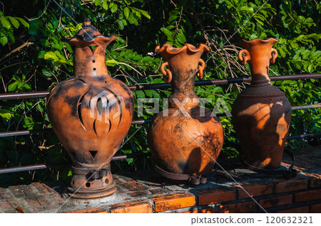 Vintage clay jugs and vases decorate the Asian garden at pagoda in summer in Asia 120632321