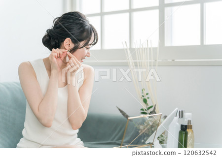 Woman choosing accessories and earrings at home 120632542