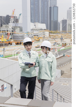 Male and female workers having a meeting at a construction site 120632730