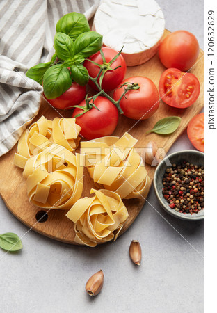 Fresh pasta, tomatoes, garlic, cheese, and basil preparing for delicious meal 120632829