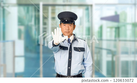 A male security guard stops a person at the building entrance A male security guard stops a person at the building entrance 120633072