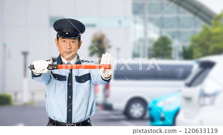 Male security guard directing traffic in a parking lot 120633119
