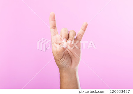 A hand displays various gestures, including a fist, open palm, and raised fingers, against a pink background. A visual exploration of communication through hand symbols A hand displays various gestures, including a fist, open palm, and raised fingers, against a pink background. A visual exploration of communication through hand symbols 120633437