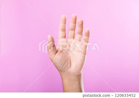 A hand displays various gestures, including a fist, open palm, and raised fingers, against a pink background. A visual exploration of communication through hand symbols A hand displays various gestures, including a fist, open palm, and raised fingers, against a pink background. A visual exploration of communication through hand symbols 120633452