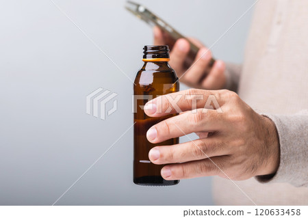 A man holds a bottle energy drink, prompting the question of its health impact-whether it boosts energy or has potential downsides. A reflection on making mindful choices for well-being 120633458