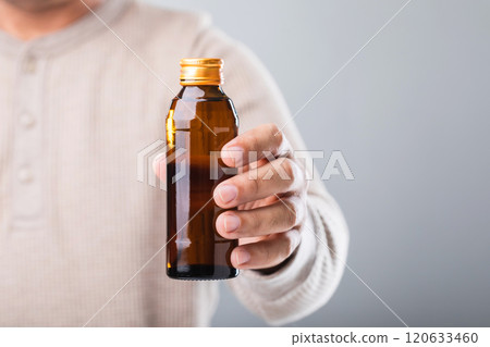 A man holds a bottle energy drink, prompting the question of its health impact-whether it boosts energy or has potential downsides. A reflection on making mindful choices for well-being 120633460