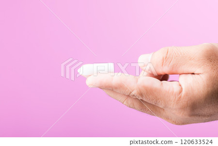 A hand holding a suppository for hemorrhoid treatment, symbolizing proactive health care and self-care. Set against a soft pink background, emphasizing the importance of managing health needs A hand holding a suppository for hemorrhoid treatment, symbolizing proactive health care and self-care. Set against a soft pink background, emphasizing the importance of managing health needs 120633524