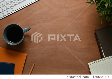 Wooden desk with cup of coffee, notepad and computer keyboard. Top view, Flat lay 120634993