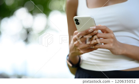 Close up athletic woman using smartphone in urban park after workout Close up athletic woman using smartphone in urban park after workout 120635052