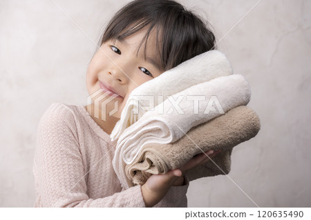 Cute girl smiling while holding a soft towel Cute girl smiling while holding a soft towel 120635490