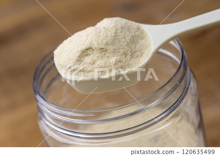 用量匙從儲存瓶中舀出蛋白粉 120635499
