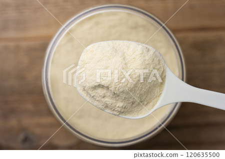 用量匙從儲存槽中舀出蛋白粉的俯視圖 120635500