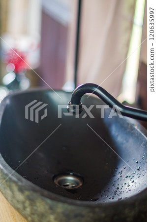 dark stone kitchen sink with black faucet in the kitchen . High quality photo dark stone kitchen sink with black faucet in the kitchen . High quality photo 120635997