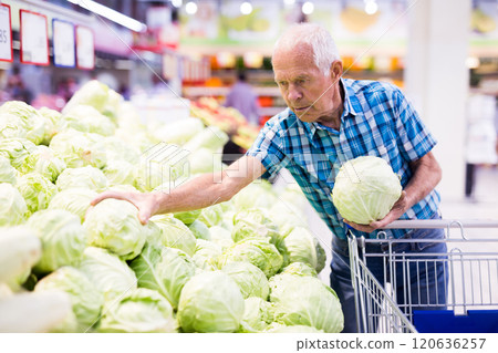 Elderly retired man buying cabbages in grocery department of the supermarket Elderly retired man buying cabbages in grocery department of the supermarket 120636257