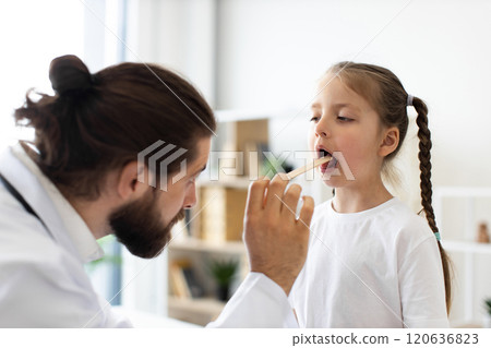 Caucasian doctor checks little girl's throat during medical examination 120636823