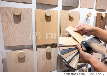 Designer hand picking sample of wood laminated from natural collection 120637217