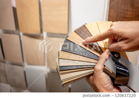 Designer hand pointing at sample of wood laminated from natural collection 120637220