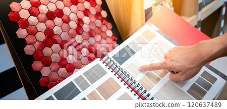Designer hand pointing at wooden laminate swatch collection in material sample catalog Designer hand pointing at wooden laminate swatch collection in material sample catalog 120637489