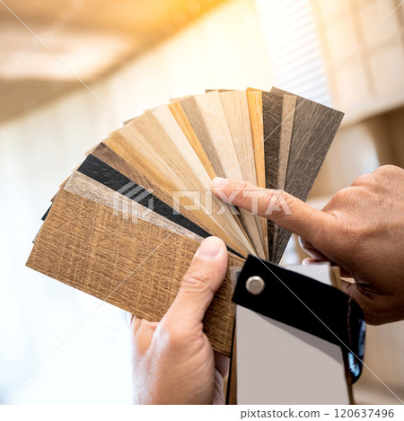 Designer hand pointing at sample of wood laminated material from natural collection Designer hand pointing at sample of wood laminated material from natural collection 120637496