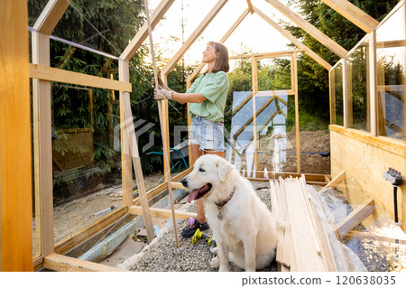 Female Carpenter with Her Dog in Greenhouse 120638035