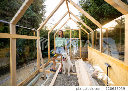 Female Carpenter with Her Dog in Greenhouse Female Carpenter with Her Dog in Greenhouse 120638039