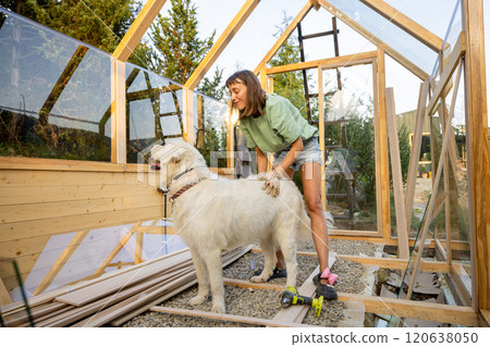 Female Carpenter Playing with Her Dog Female Carpenter Playing with Her Dog 120638050