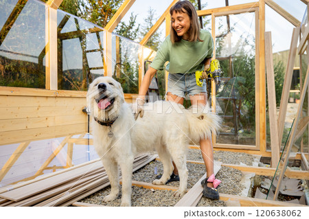 Female Carpenter Playing with Her Dog 120638062