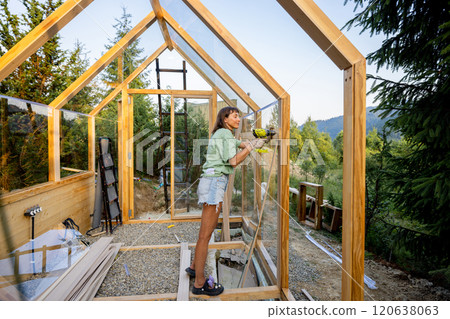 Female Carpenter Assembling Greenhouse 120638063