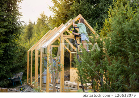 Female Carpenter Working on Greenhouse Female Carpenter Working on Greenhouse 120638079