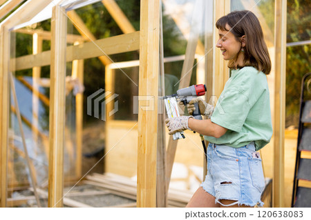 Female Carpenter Using Nail Gun Female Carpenter Using Nail Gun 120638083