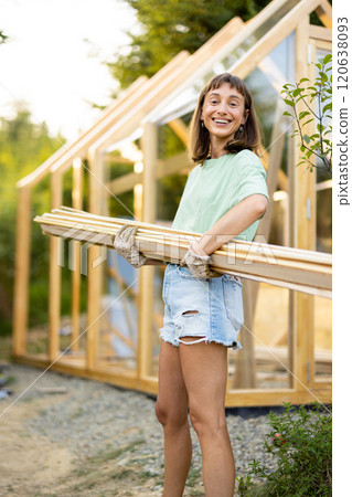 Female Carpenter Carrying Wooden Planks 120638093
