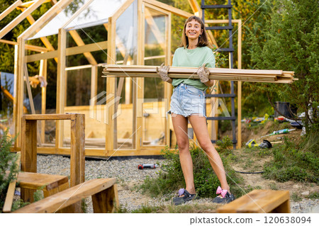 Female Carpenter Carrying Wooden Planks 120638094