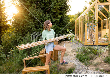Female Carpenter Carrying Wooden Planks 120638096