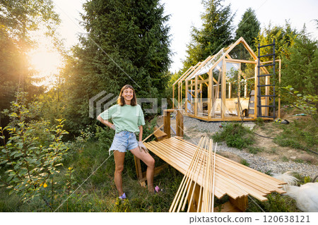 Carpenter standing next to a partially built wooden greenhouse Carpenter standing next to a partially built wooden greenhouse 120638121