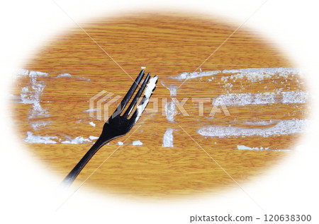 一個人用叉子舀出粘在薄餅上的奶油的場景，該奶油從酥餅上取下並放在木紋桌子上。 120638300