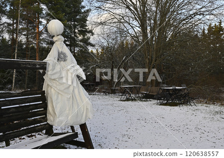 a winter scene in an outdoor setting featuring a rustic bench adorned with a unique handmade figure resembling a snowman or scarecrow a winter scene in an outdoor setting featuring a rustic bench adorned with a unique handmade figure resembling a snowman or scarecrow 120638557