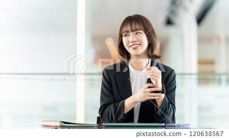 Smiling woman/businesswoman doing desk work Smiling woman/businesswoman doing desk work 120638567
