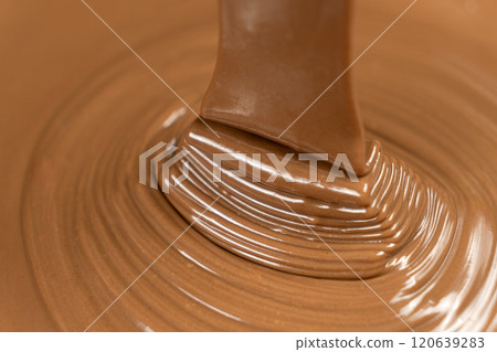 Melted milk chocolate pouring, chocolate texture. Melted milk chocolate pouring, chocolate texture. 120639283