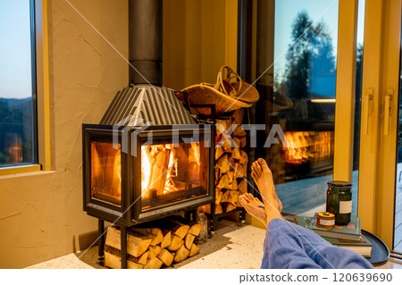 Relaxing by the fireplace Relaxing by the fireplace 120639690