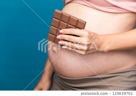 Pregnant woman showcasing chocolate cravings Pregnant woman showcasing chocolate cravings 120639701