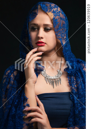 A woman in a dress and a lace cloak with a hood A woman in a dress and a lace cloak with a hood 120639919