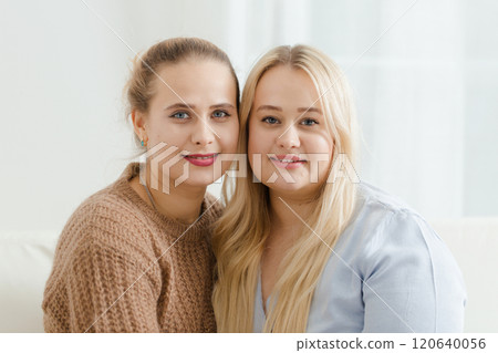 Close-up portrait of two fair-haired plump women on a light background Close-up portrait of two fair-haired plump women on a light background 120640056
