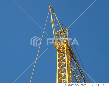 yellow tower crane over blue sky 120641148